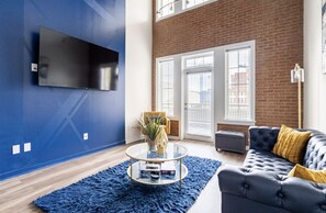 Relax in this stylish living room with a flat-screen TV, comfortable sofa, and glass coffee table.