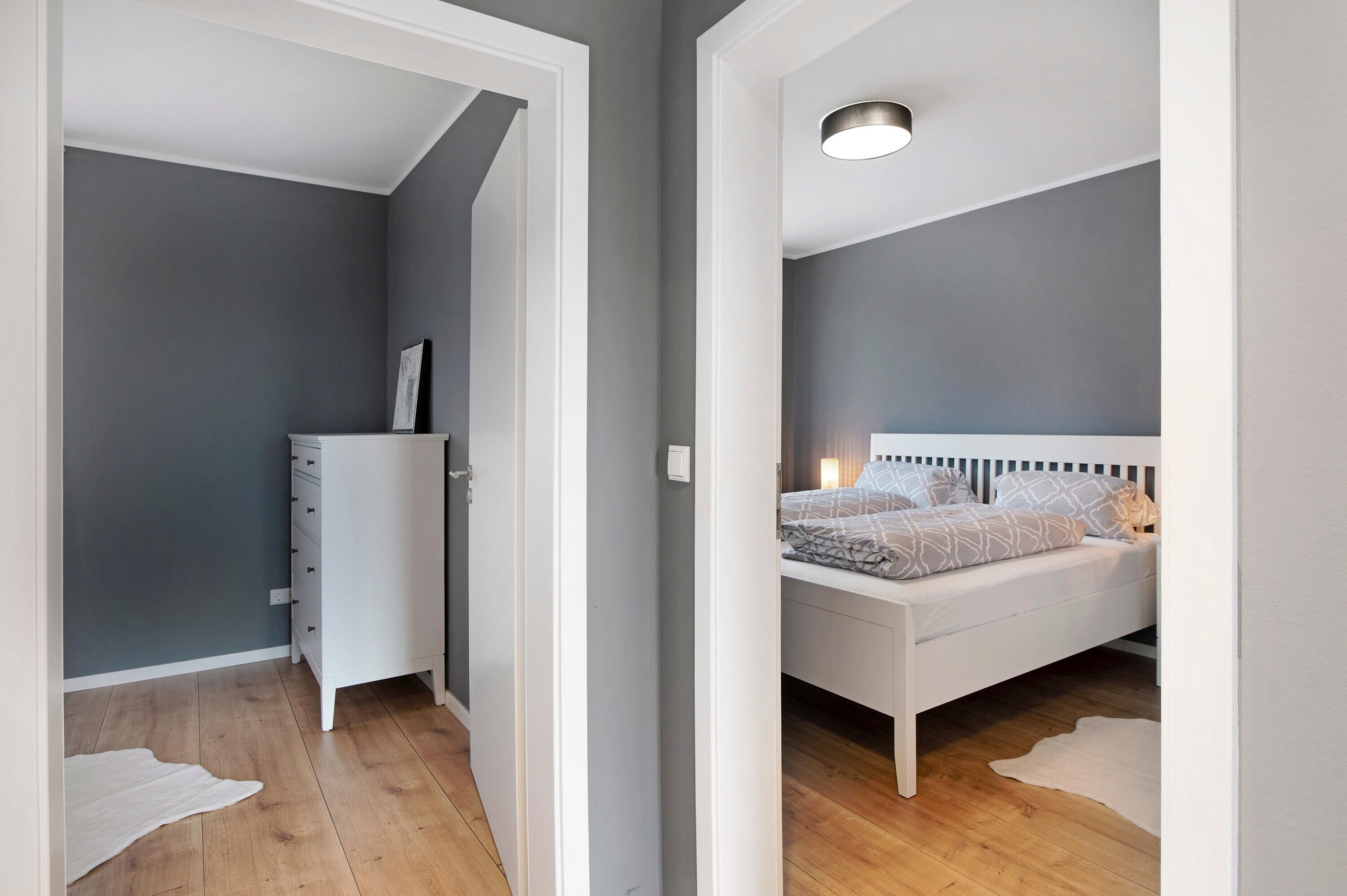 Une chambre à coucher avec un lit, une commode et une table de chevet.