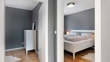 Une chambre à coucher avec un lit, une commode et une table de chevet.
