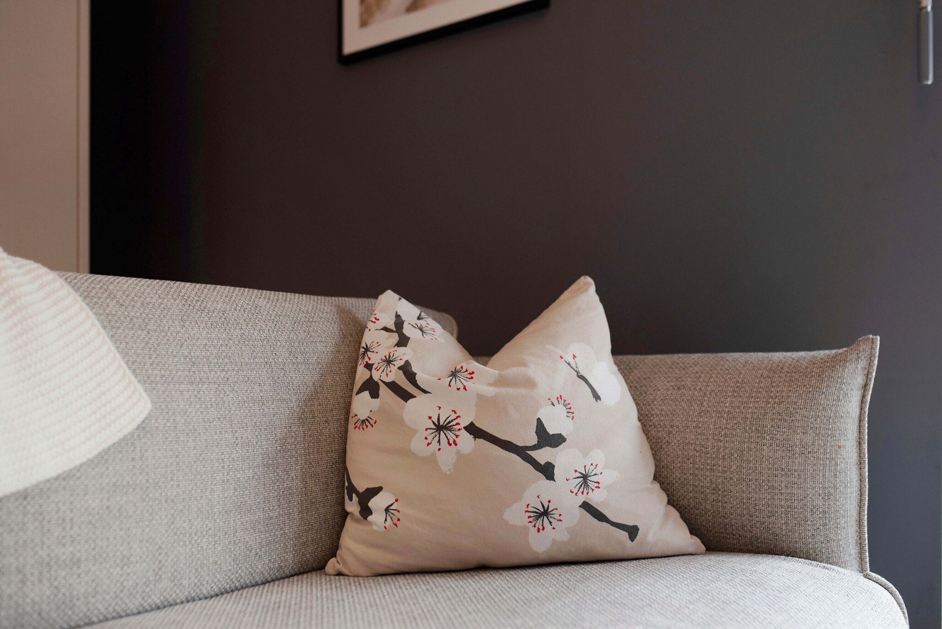 A sofa with a cushion featuring a floral pattern.