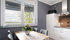 A modern kitchen with white cabinets, a microwave, and a countertop with kitchen items. - Holiday Apartment "B5" with Mountain View, Balcony & Wi-Fi (Bad Bellingen)