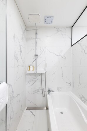Une salle de bain moderne avec un mur en marbre blanc, une douche intégrée et une baignoire.