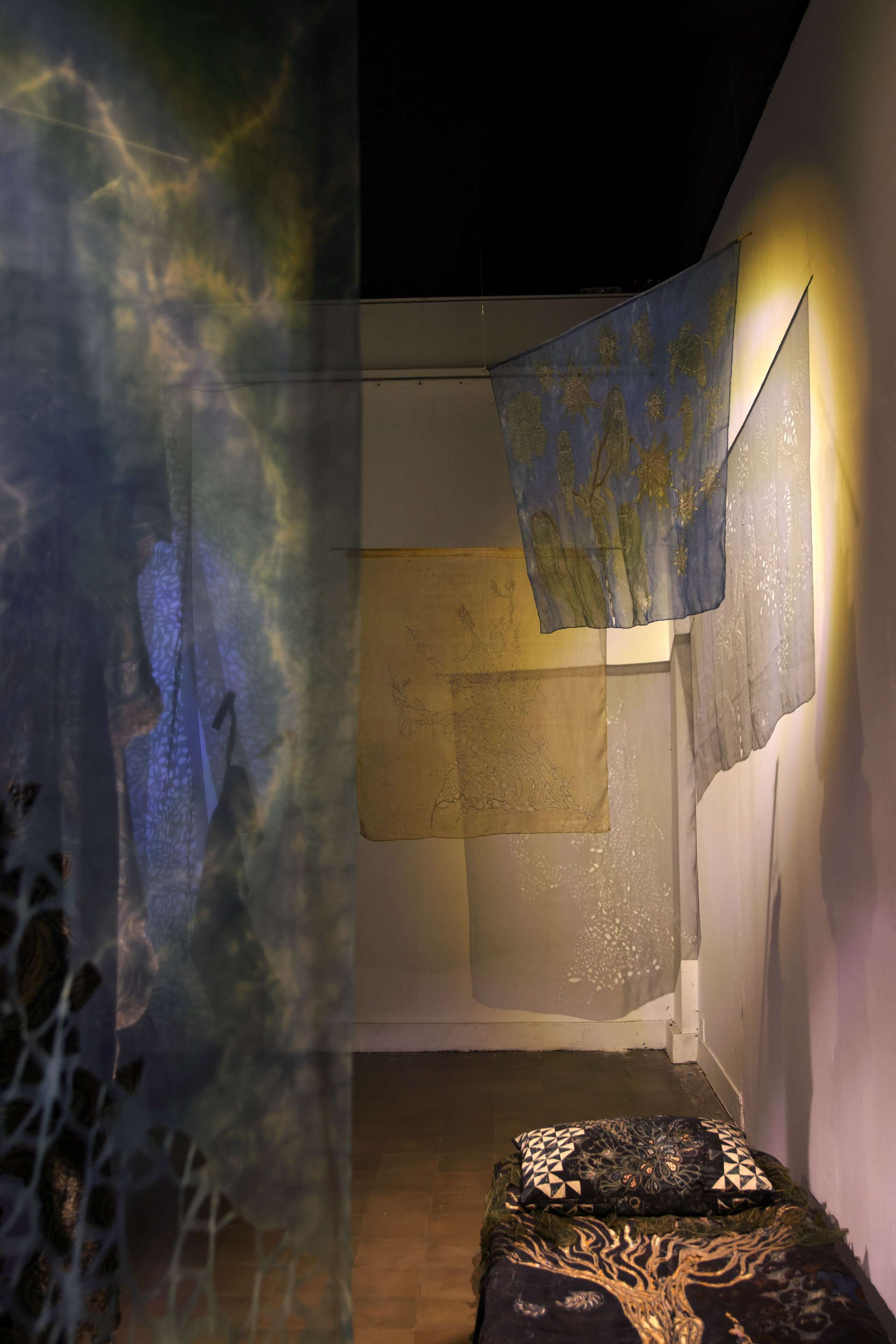 Ein Zimmer mit einem Bett, einem an der Wand montierten Projektor und einem gemusterten Vorhang.