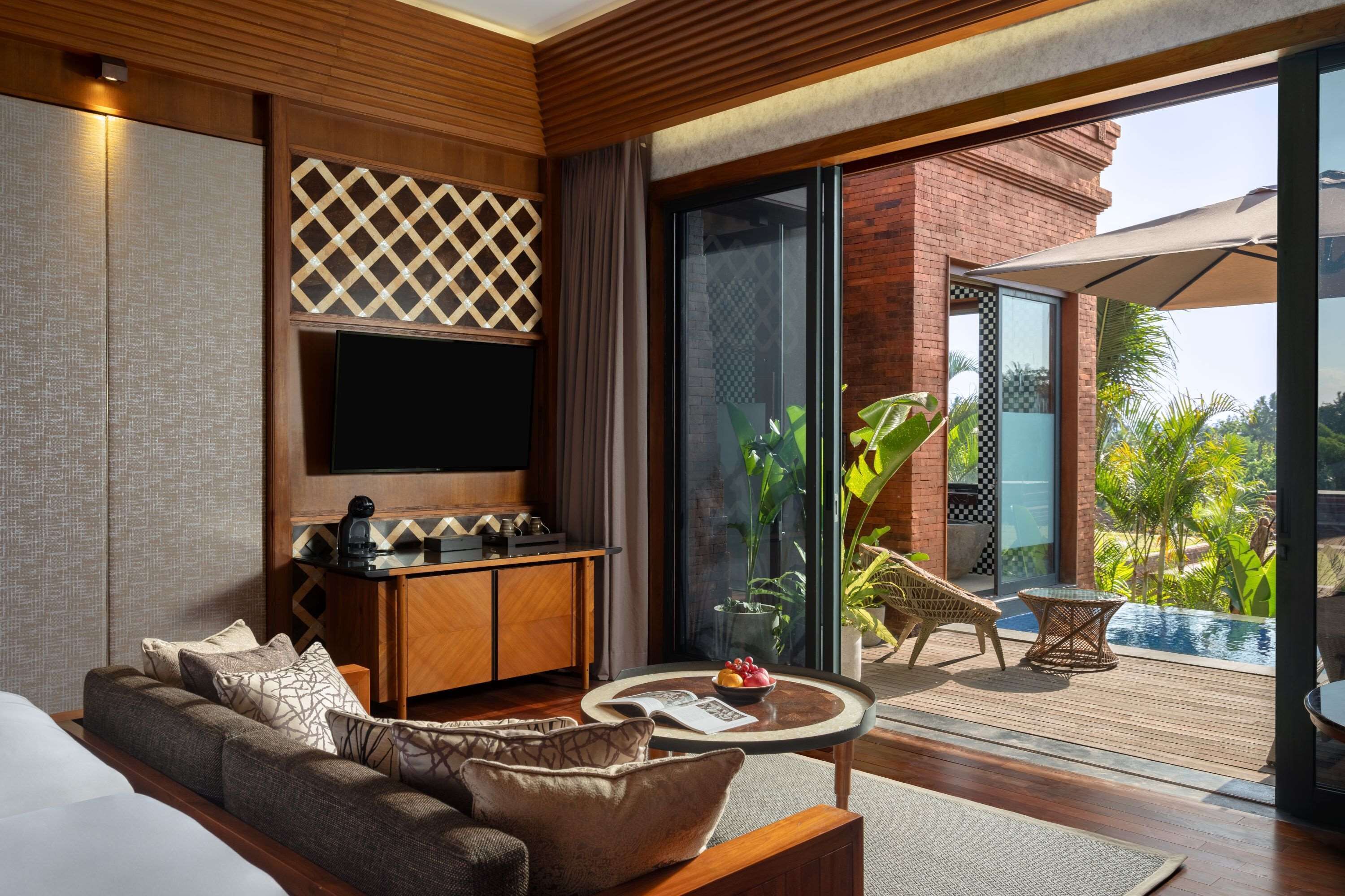 A modern living room with a sofa, coffee table, and a TV mounted on the wall.