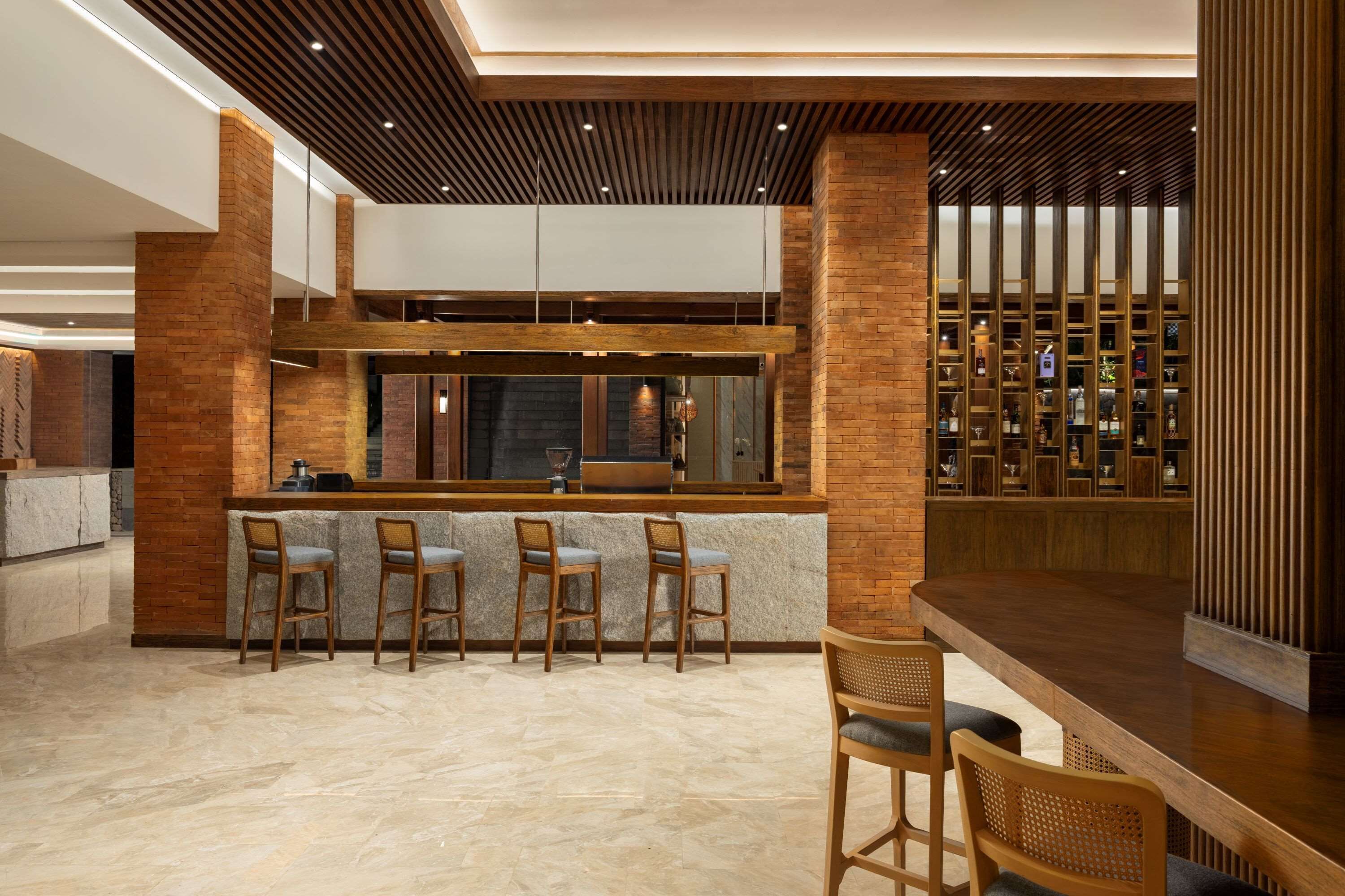 A modern bar area with a high counter, bar stools, and a wine display.