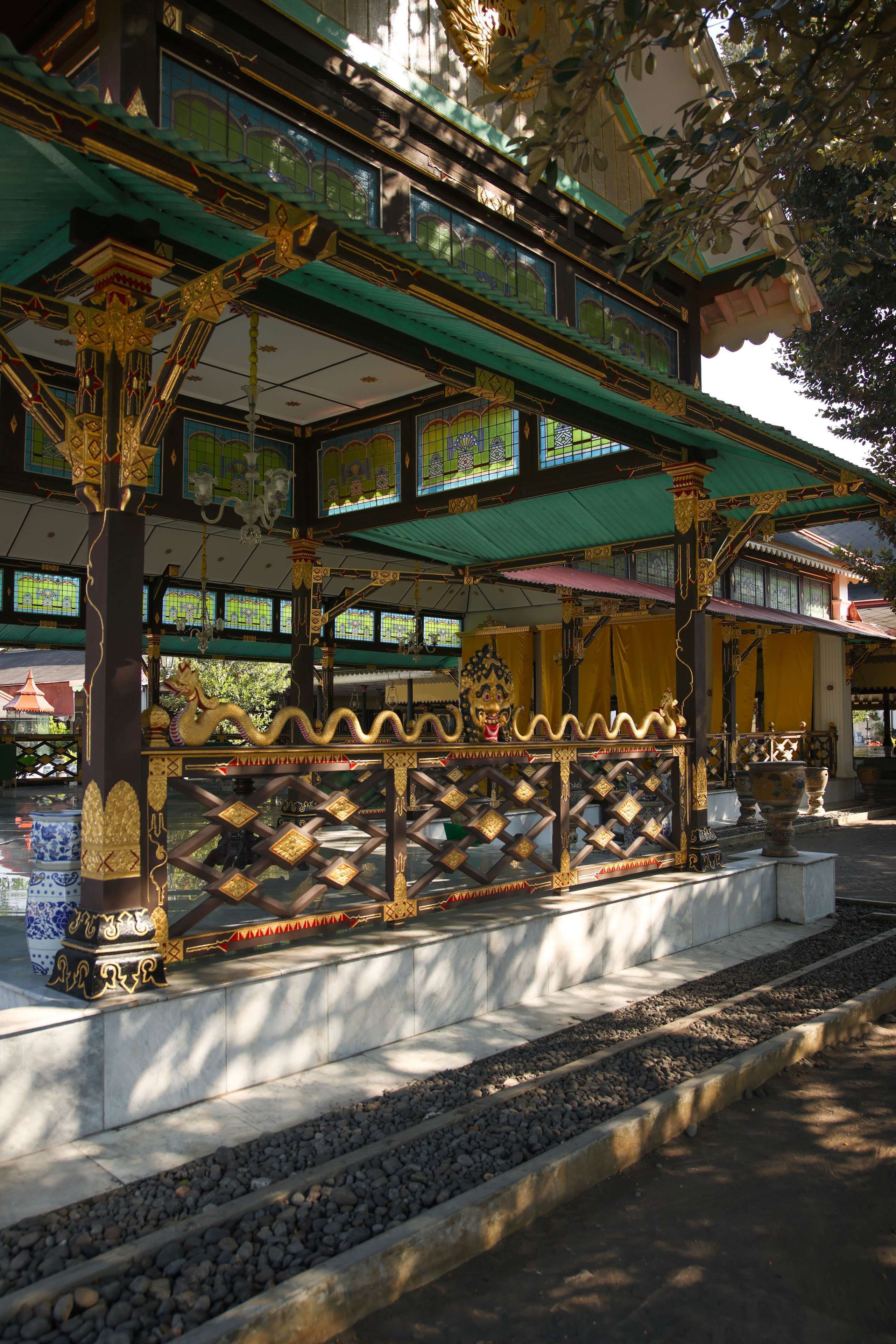A traditional Balinese temple with ornate architecture, including a golden dragon sculpture and intricate woodwork.