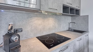 A modern kitchen with a built-in stove, a microwave, and a sink.