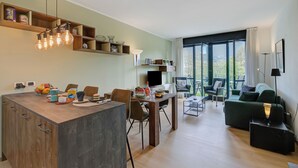 A modern living space with a dining area, a sofa, and a TV. - Porto Letizia P5, Porlezza, Italy (Porlezza)