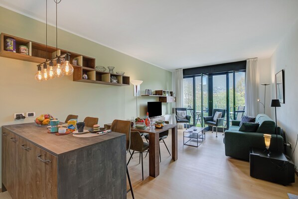 A modern living space with a dining area, a sofa, and a TV.