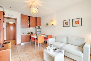 A modern apartment with a dining area, kitchen, and living room.