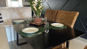 A dining table set with plates, cutlery, and a potted plant. - A taste of paradise, luxury villa on the beautiful Northern Coast! (Florence Hall Village)