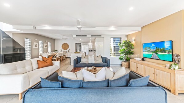 A modern living room with a sofa set, a coffee table, and a television on a wooden cabinet.