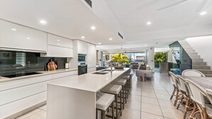 A modern kitchen with a central island, built-in appliances, and a view to the outdoor area.