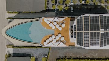 Alberca al aire libre, sombrillas en la alberca y camastros