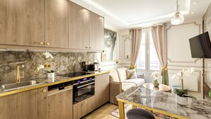 Una cocina moderna con encimera de mármol, armarios de madera y horno empotrado.