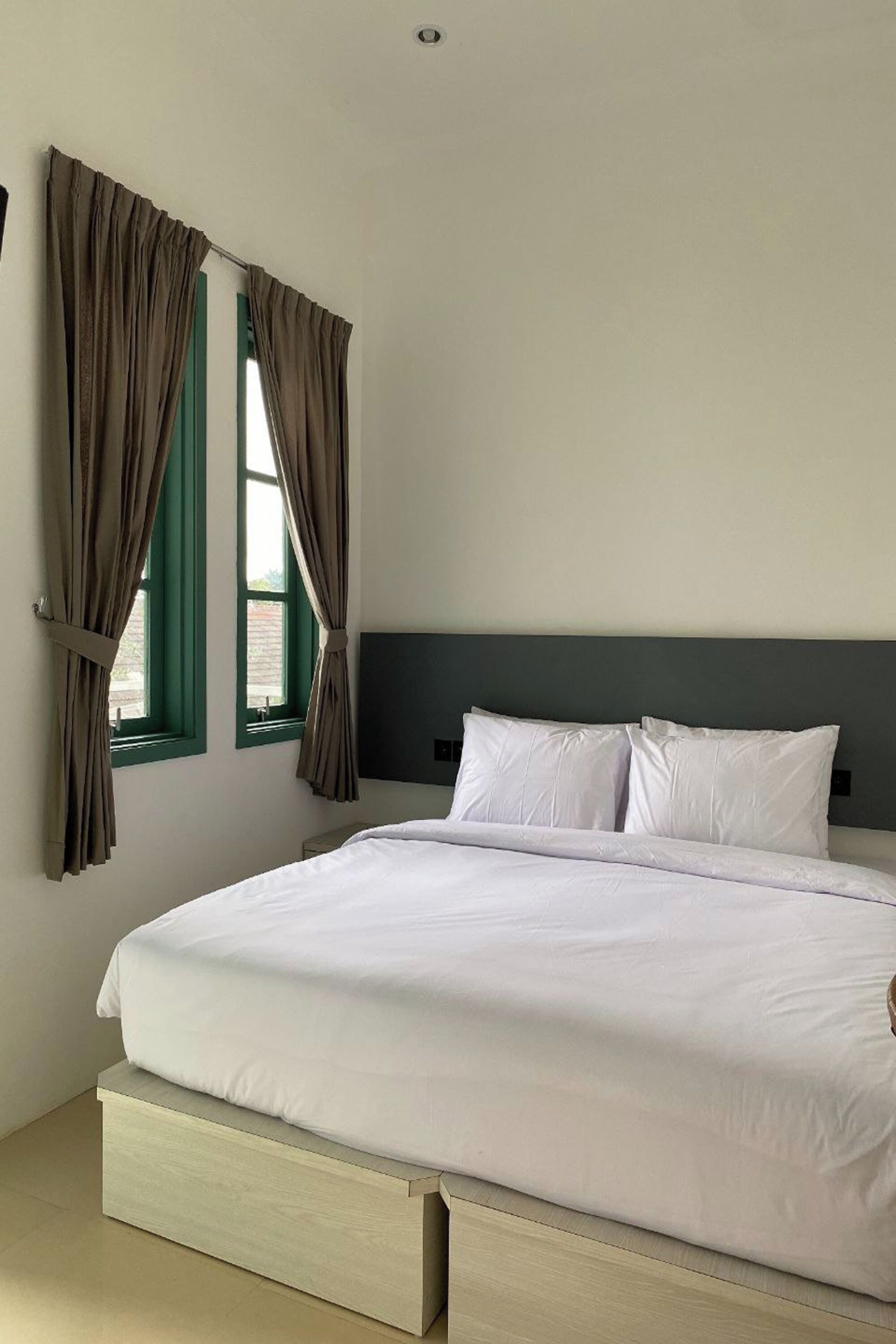 Un dormitorio con cama, cortinas y ventana.