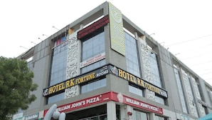 A building with multiple businesses including Hotel R K Fortune Rooms and William John's Pizza. - HOTEL R K FORTUNE (Gandhinagar)