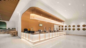 A modern reception area with a curved counter, seating area, and decorative wall elements. - Quantum Inn East Railway Station (Hangzhou)