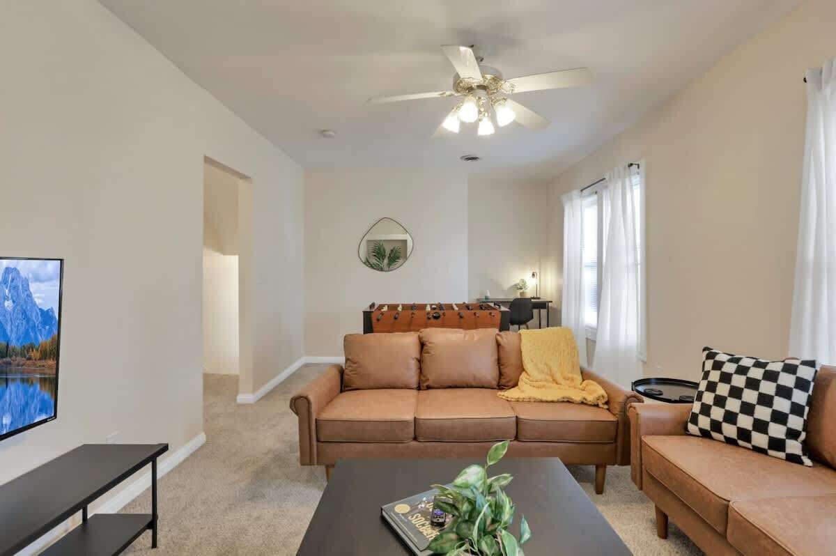 A living room with a sofa, coffee table, and a ceiling fan.