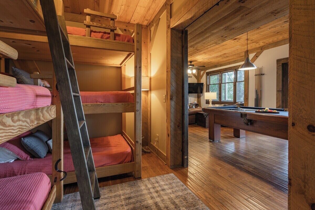 Un chalet confortable avec des lits superposés, une table de billard et un intérieur en bois.
