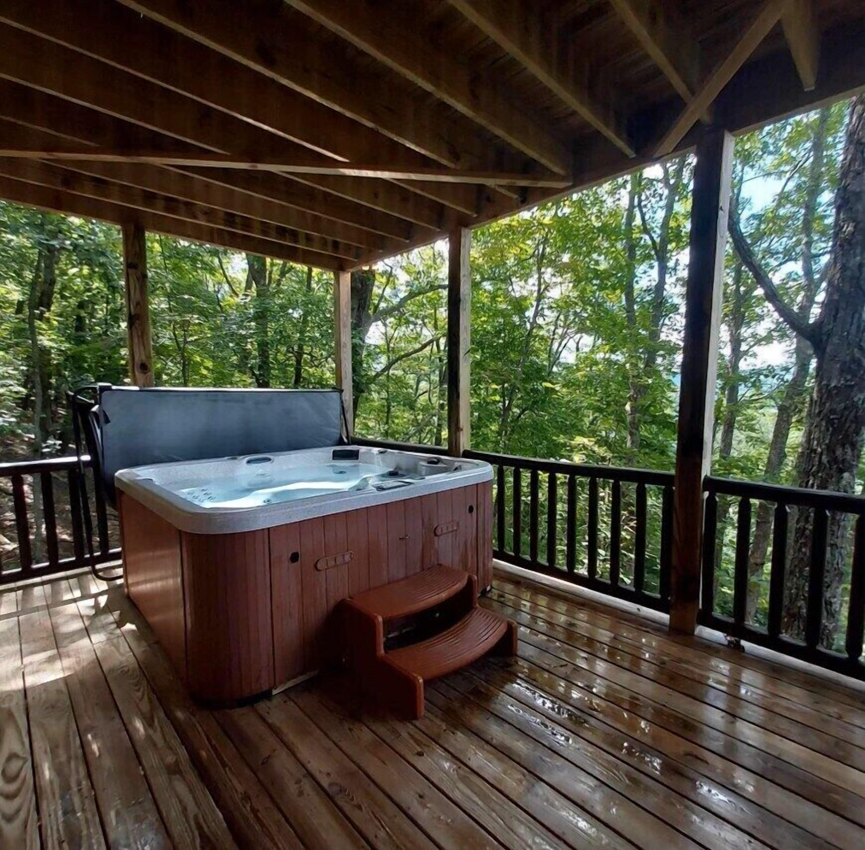 A hot tub on a wooden deck with a view of trees.