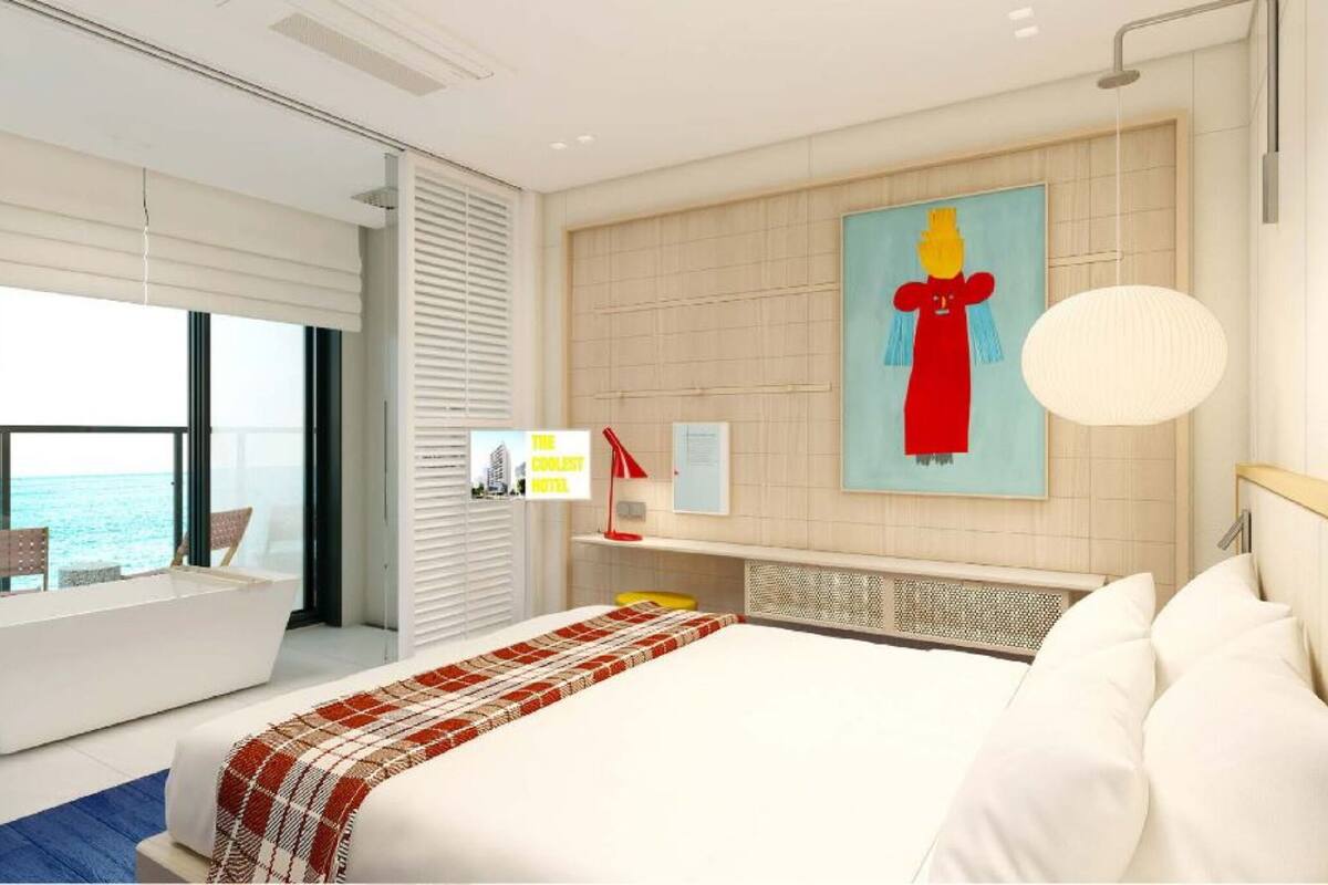 Una habitación de hotel moderna con una cama grande, vistas al mar y un cuadro en la pared.