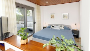 A bedroom with a bed, a desk with a computer, a TV, and two bedside tables with lamps. - MARTHA'S HOME. Beautiful and comfortable house in Rhodes. (Rodos)