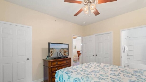 A bedroom with a bed, a dresser, a television, and a ceiling fan. - 2 Bedroom- Resort Pool- 1st Floor- Golf (North Myrtle Beach)