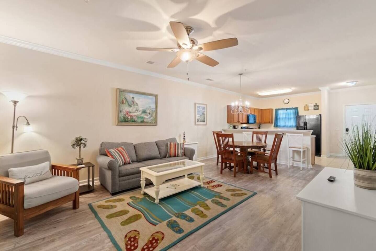 A living room with a sofa, coffee table, and a dining area with chairs and a table.