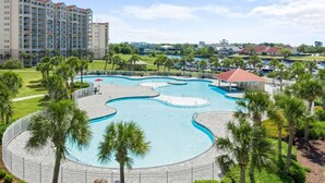A resort with a large pool area, palm trees, and a building in the background. - 2 Bedroom- Resort Pool- 1st Floor- Golf (North Myrtle Beach)