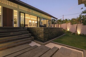 Uma casa moderna com fachada de pedra, amplas janelas e entrada bem iluminada.