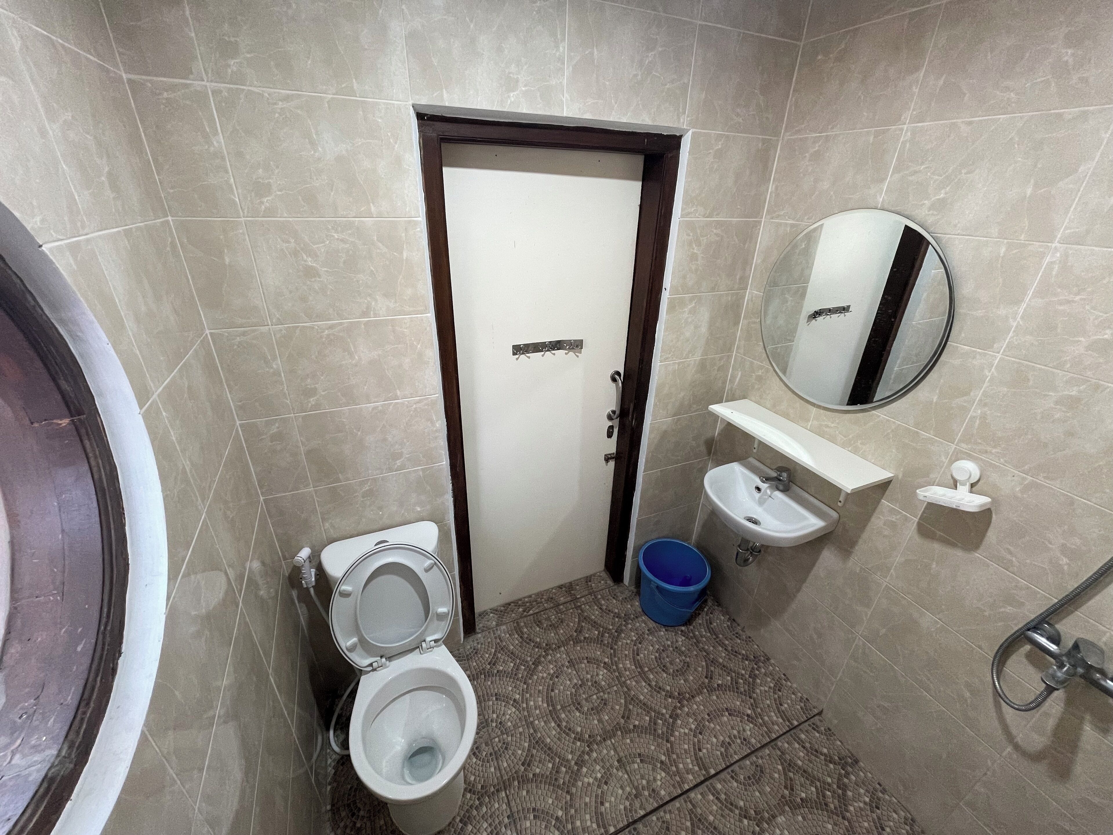 Une salle de bain avec des toilettes, un lavabo et un miroir.