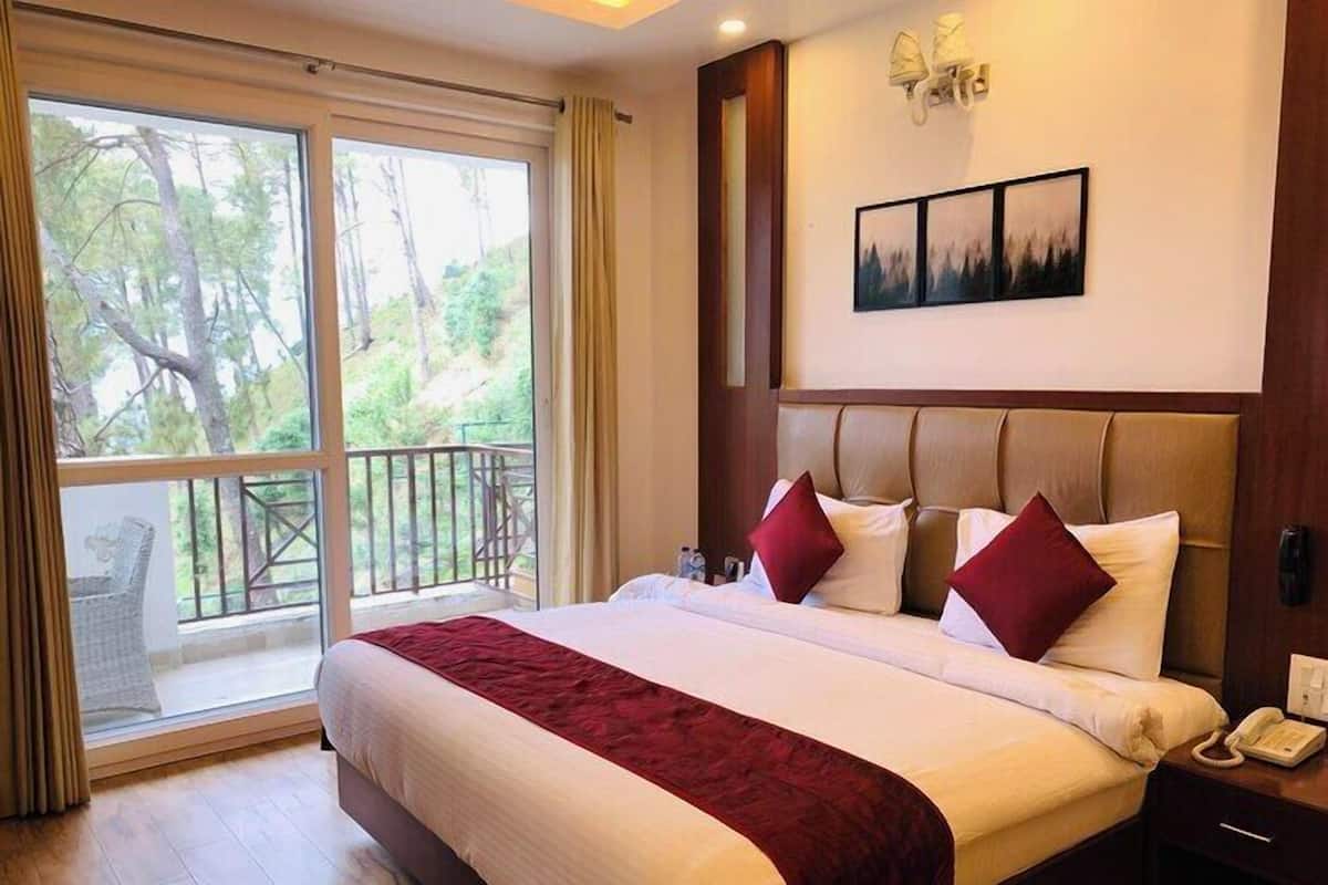 Una habitación de hotel con una cama grande, un balcón con vistas a árboles, un cabecero de madera y un cuadro en la pared.
