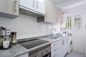 Una cucina moderna con macchina del caffè, forno a microonde e forno integrato.