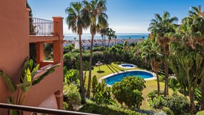 A pool surrounded by palm trees and a view of the ocean. - Apartment 'Casa Vasari' with Sea View, Wi-Fi and Air Conditioning (Manilva)