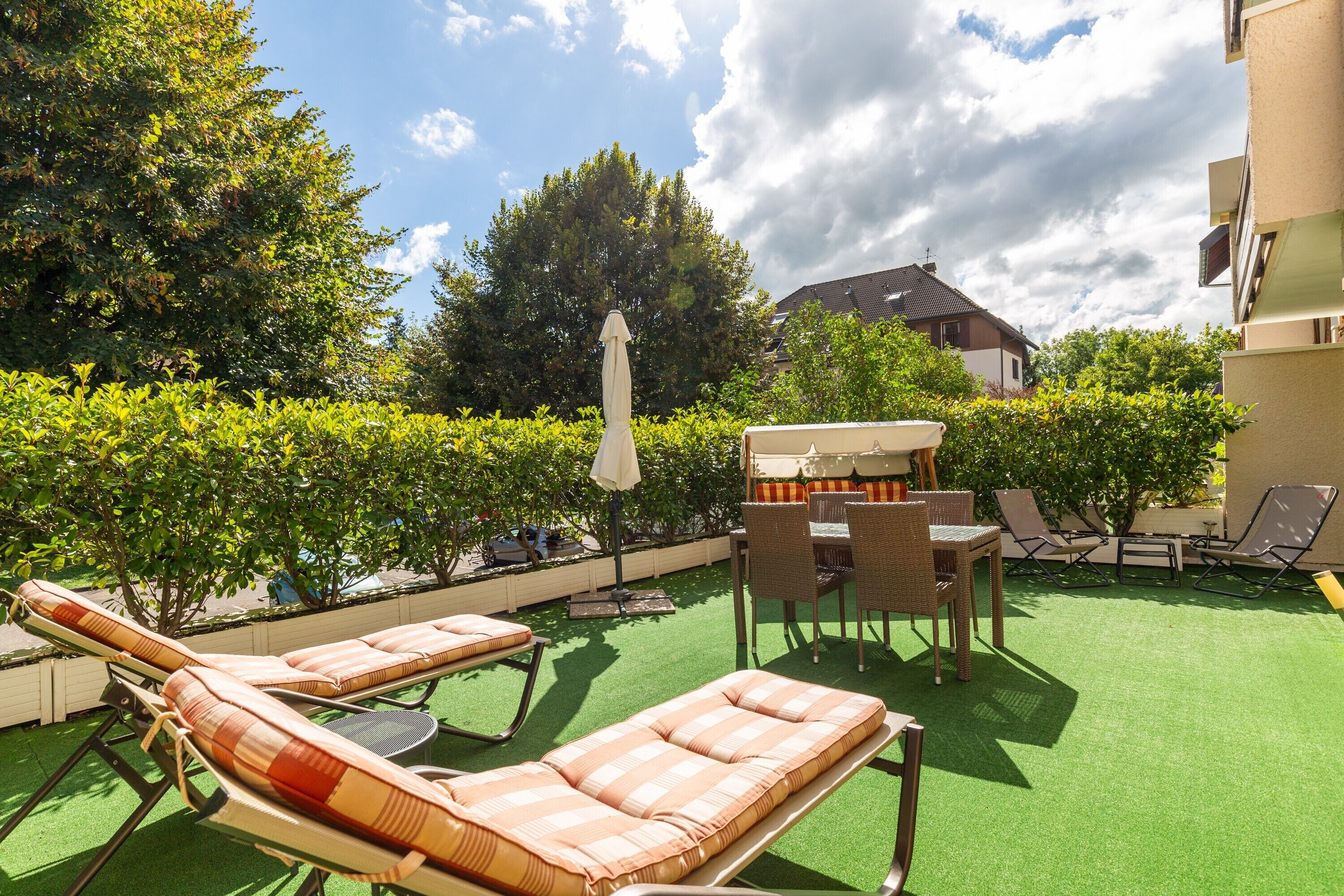 Een dakterras met loungezetels, een tafel en een barbecue.