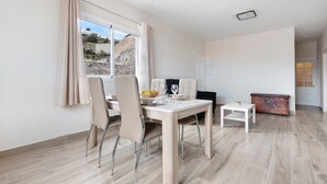 Un comedor con una mesa, sillas y vistas al exterior por una ventana.