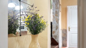 A vase with flowers on a table, a mirror reflecting the flowers, and a door in the background. - Vacation Home 'Los Nardos' with Sea View, Private Terrace and Private Garden (La Orotava)