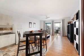 Una cocina moderna con comedor, ventilador de techo y vistas al exterior.