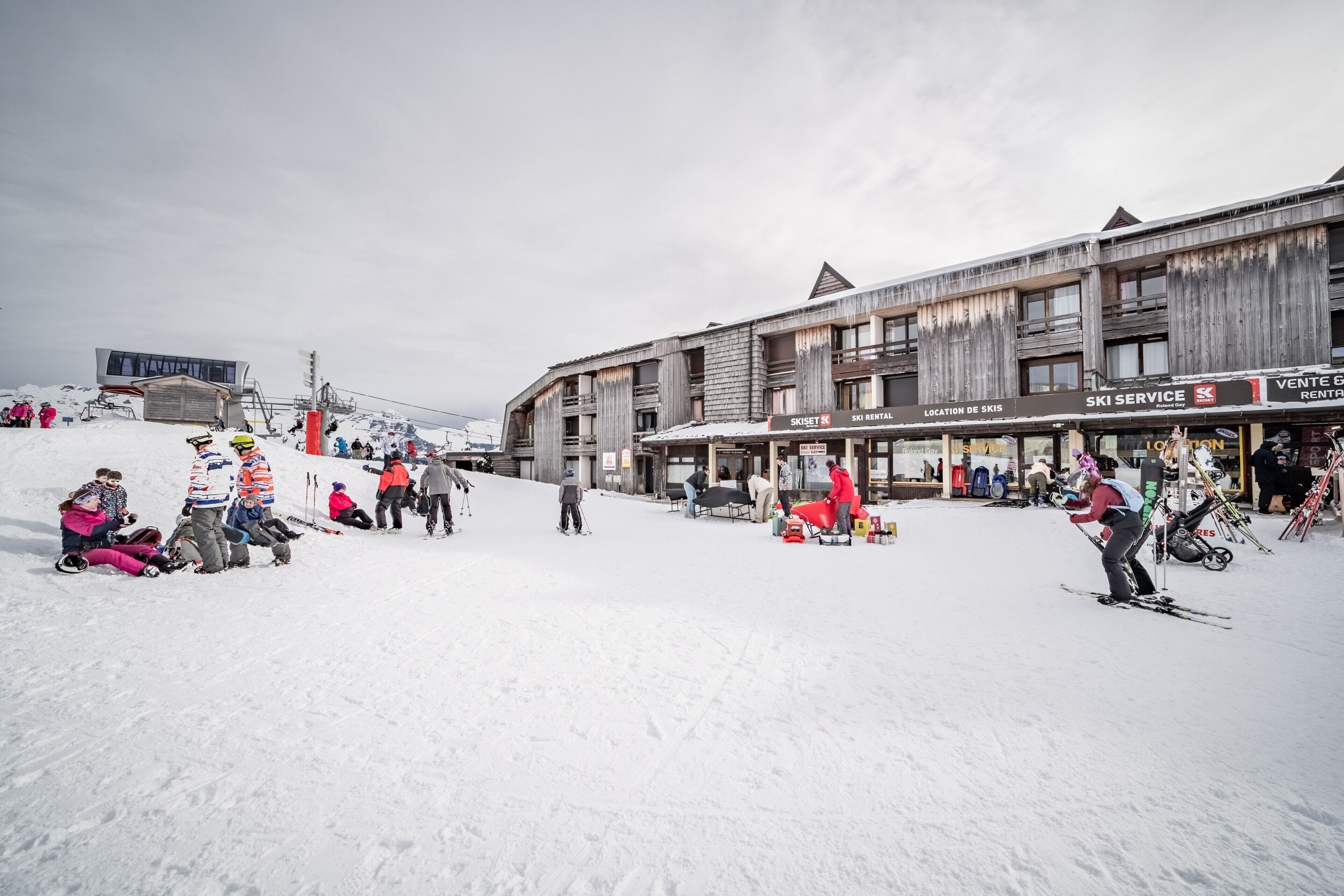 A ski resort with a ski rental shop, ski service, and a location sign.
