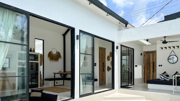 A modern interior with a glass-enclosed living area, a pool, and a dining space.
