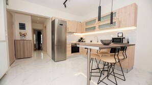 Una cocina moderna con una isla central, electrodomésticos de acero inoxidable y armarios de madera.