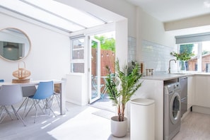 Enjoy meals in the kitchen with a washing machine, dining area, and large window offering a view of the outdoors.