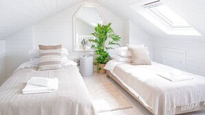 A cozy, white-themed bedroom with two beds, a large window, and a potted plant. - Stunning Townhouse with Large Garden - Sleeps 8 (Cheltenham)