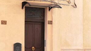 A brown door with a brass doorknob, flanked by two mailboxes, and a number '52' on the left and '50' on the right. - Segesta - Dream Room (Salemi)