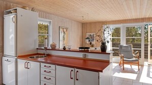 Een moderne keuken met houten kastjes, een roestvrijstalen spoelbak en een houten aanrecht.