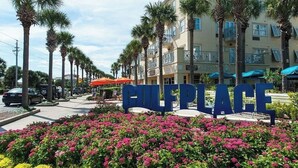 A hotel entrance with a sign reading "ELLEPLACE," surrounded by palm trees and colorful flowers. - 🦩Book Me Baby! 30A Oasis~Private Heated Pool~Pet-Friendly🦩 (Santa Rosa Beach)