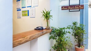 A reception desk with a wooden counter, a potted plant, and a sign reading "Alona Beach Side Inn". - ALONA BEACH SIDE INN (Panglao)