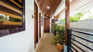 A corridor with wooden ceiling, potted plants, and a railing. - ALONA BEACH SIDE INN (Panglao)