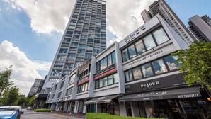 Un edificio moderno con diversi spazi commerciali, tra cui una caffetteria, una panetteria e un asilo nido.